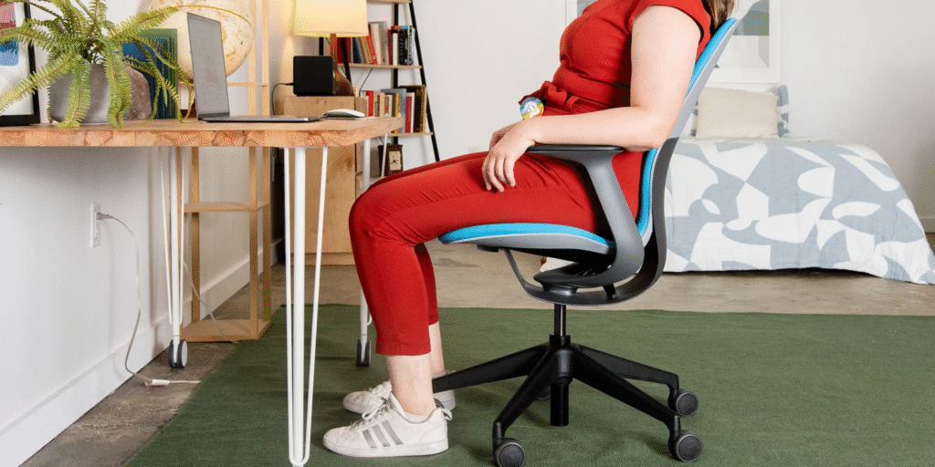 Woman sitting on an ergonomic chair at a workstation