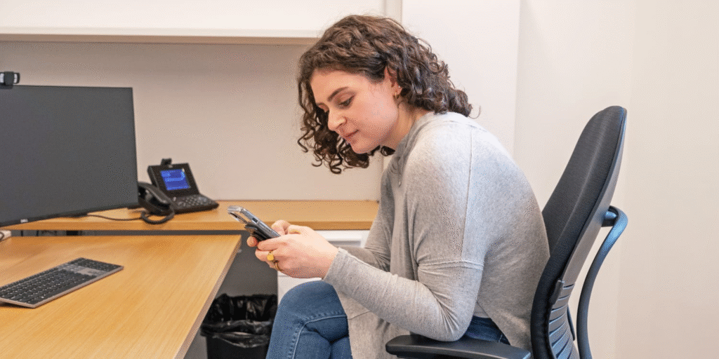 woman texting at phone and getting tech neck