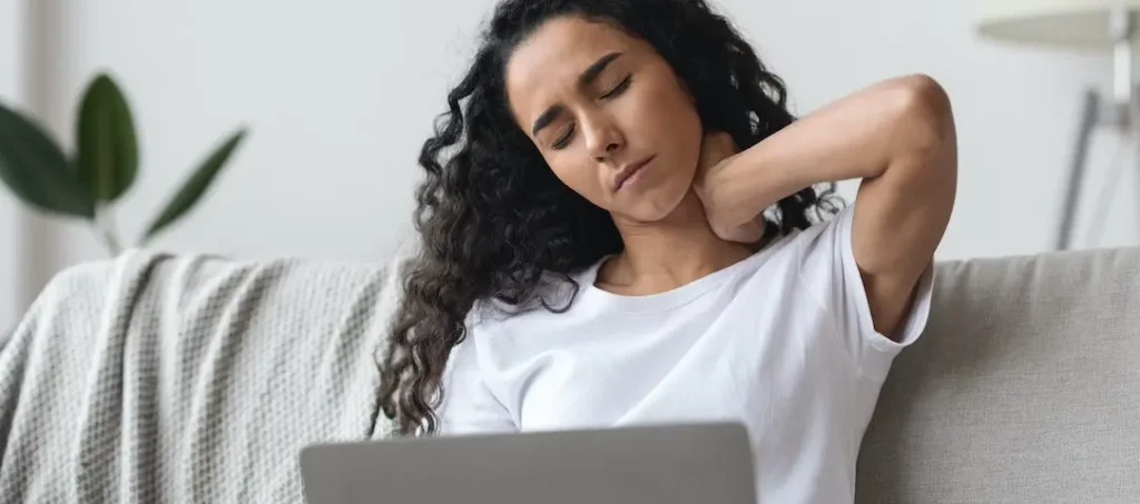 Woman experiencing tech neck from working unergonomically