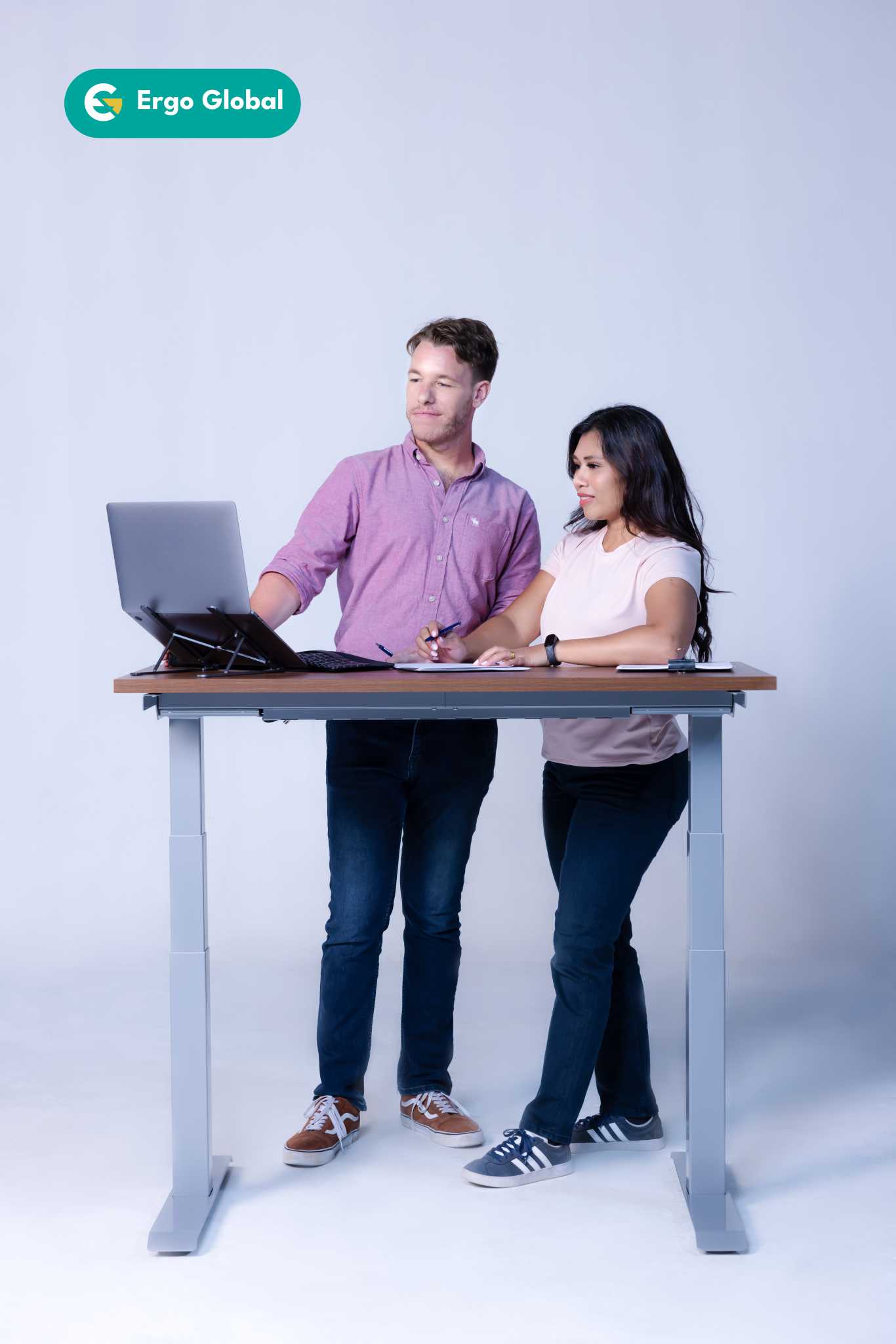 Two employees standing at a standing desk