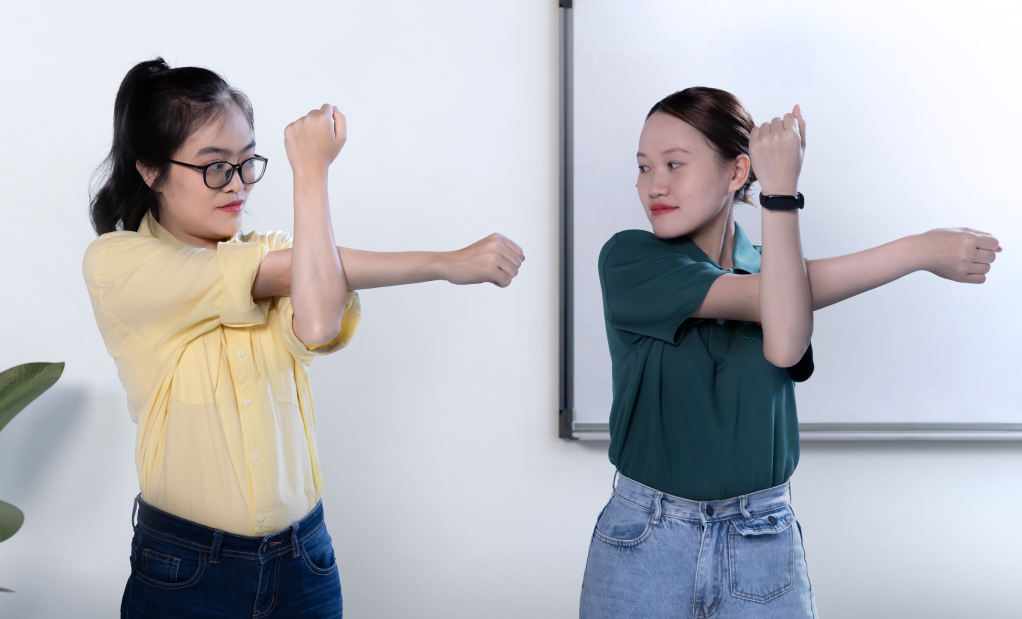 a certified ergonomics specialist showing an employee how to incorporate movement into their daily routine