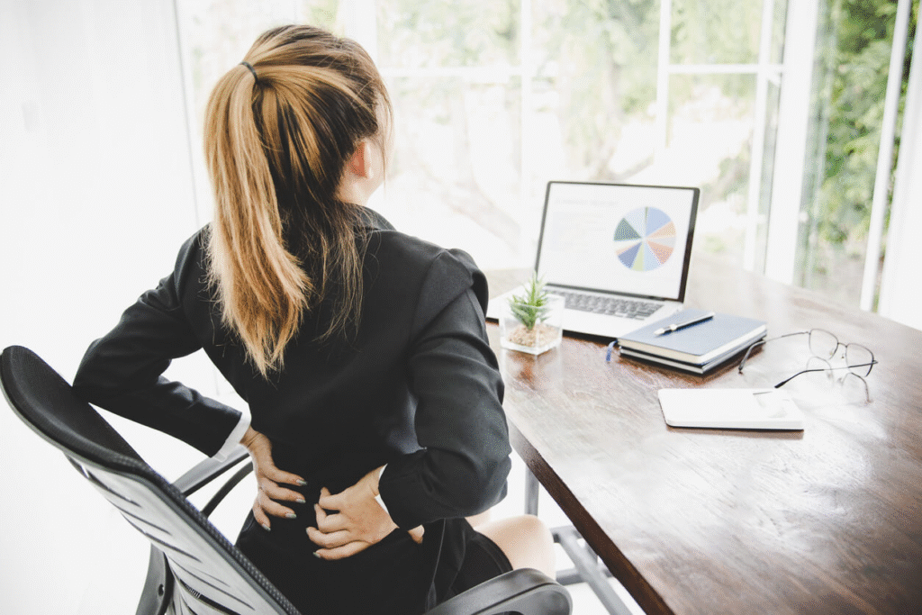 Employee with back pain at a sitting desk