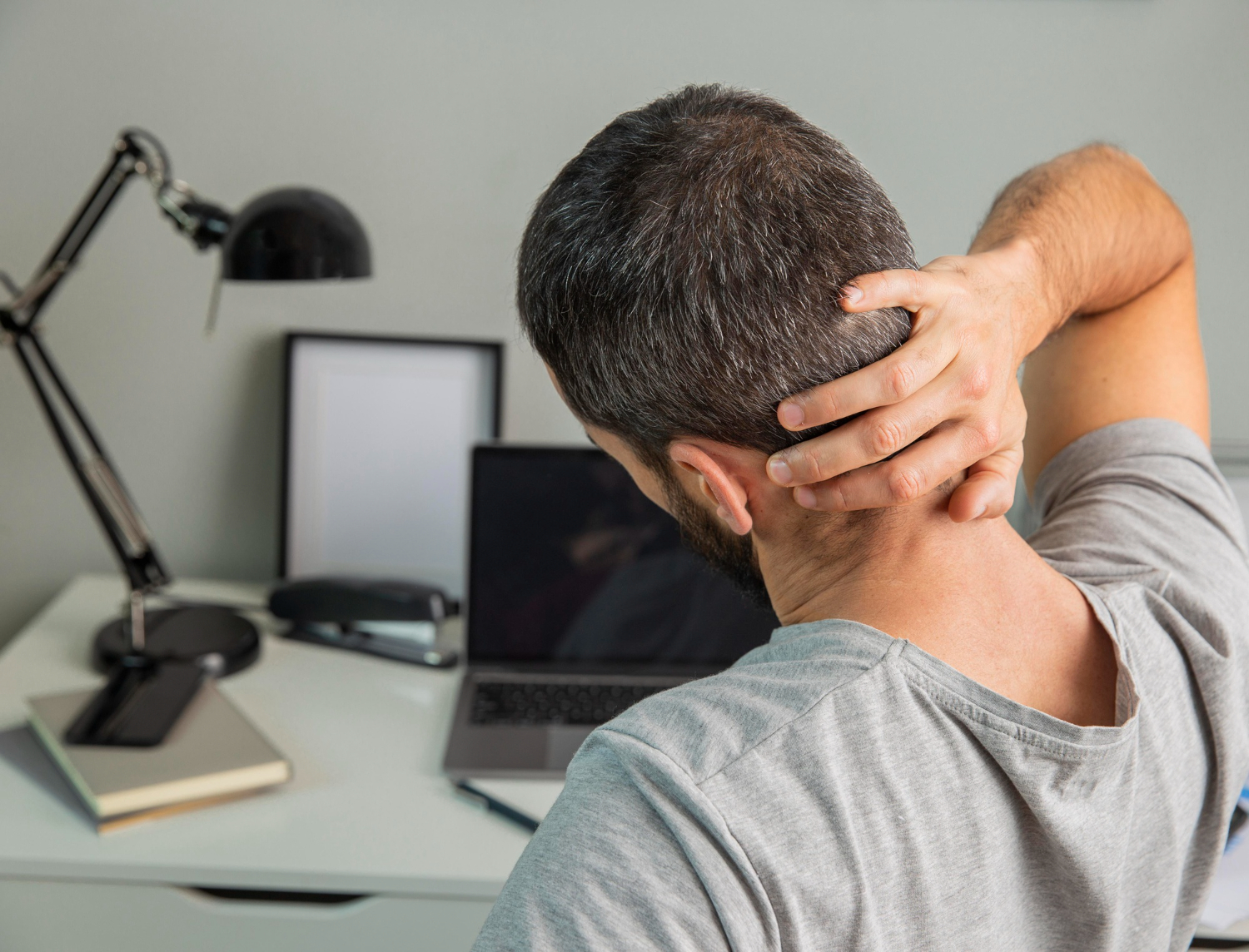 An office worker suffering from poor static loading ergonomics