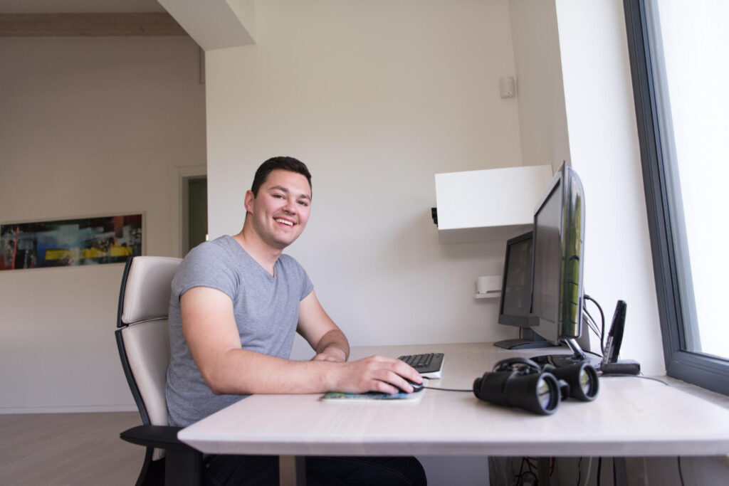 Person happily working at a simple, yet ergonomic office setup.