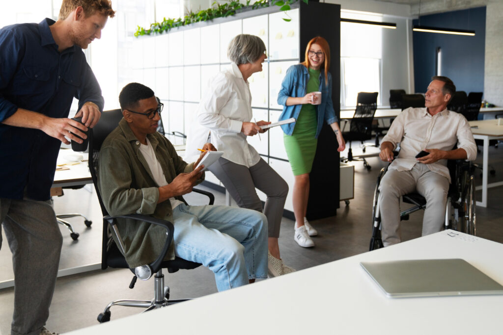 Group of diverse professionals collaborating in a well-lit, open-plan office with good ergonomic office design.