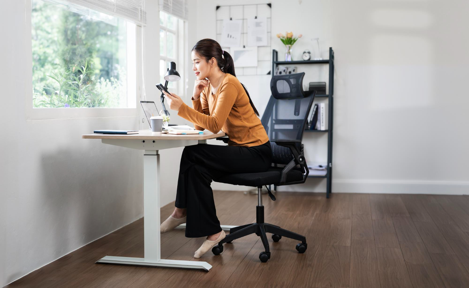 Person happily working at an ergonomic office set up.
