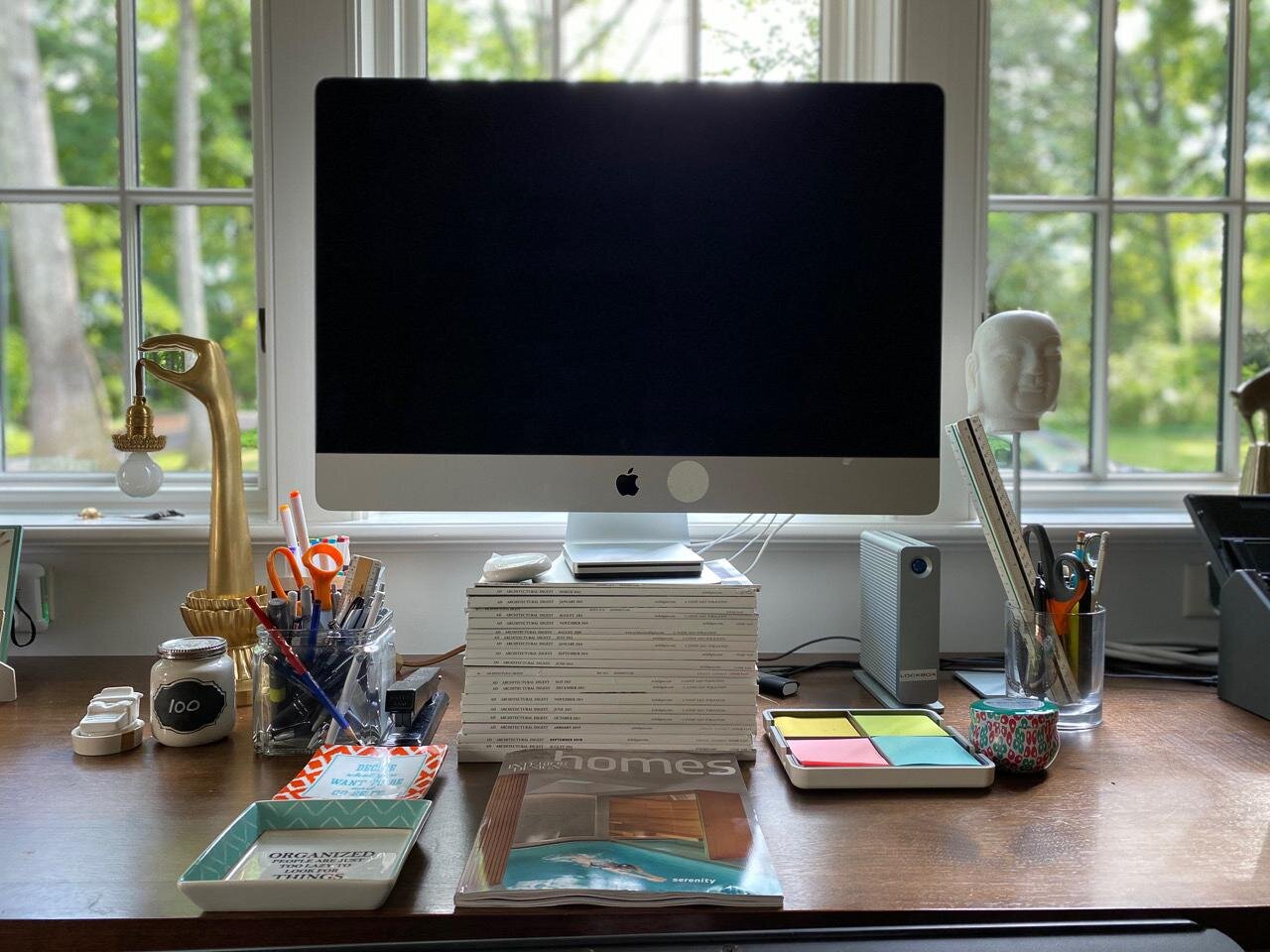 Adjusting monitor height with a stack of books for an ergonomic office setup.