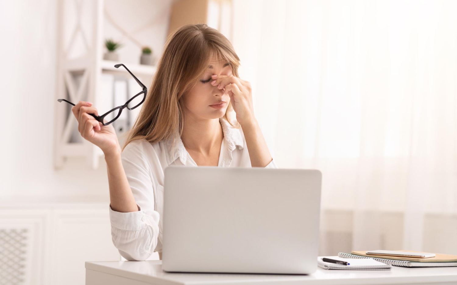 Person rubbing their eyes, experiencing eye strain.