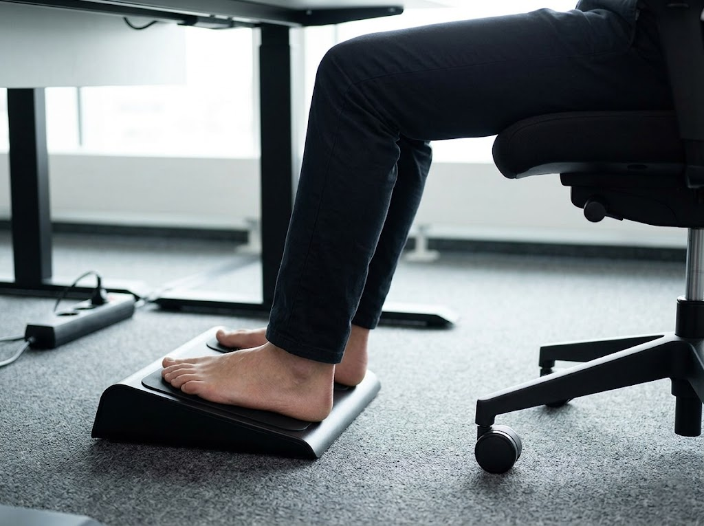 Man with flat feet on sleek ergonomic footrest. 