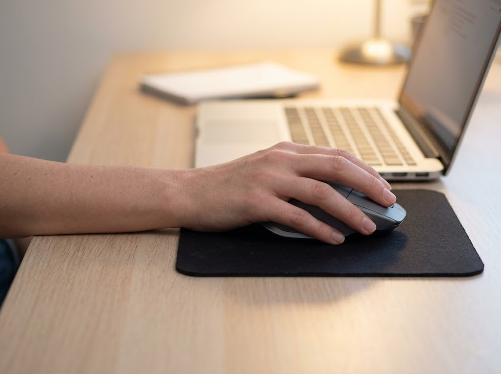 Close-up of a relaxed hand comfortably using an external mouse.
