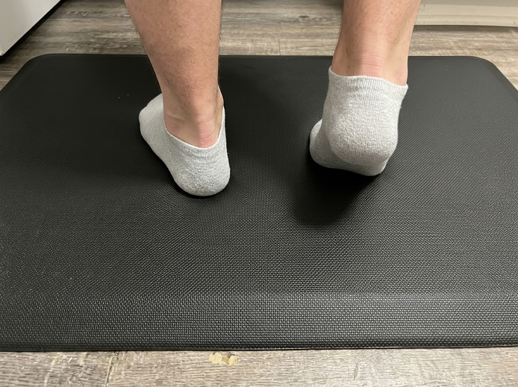 Feet shifting on a textured anti-fatigue mat. 