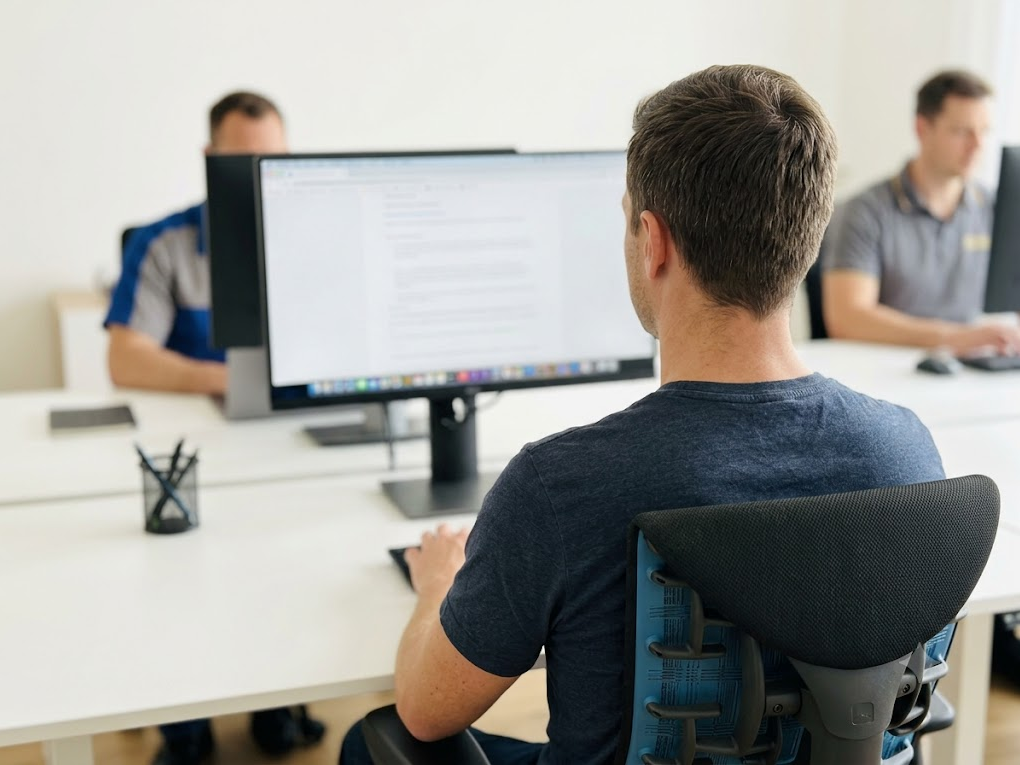 An office worker sitting with excellent posture and monitor height. 