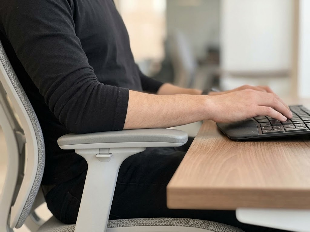 Forearm resting on armrest at relaxed elbow angle. 