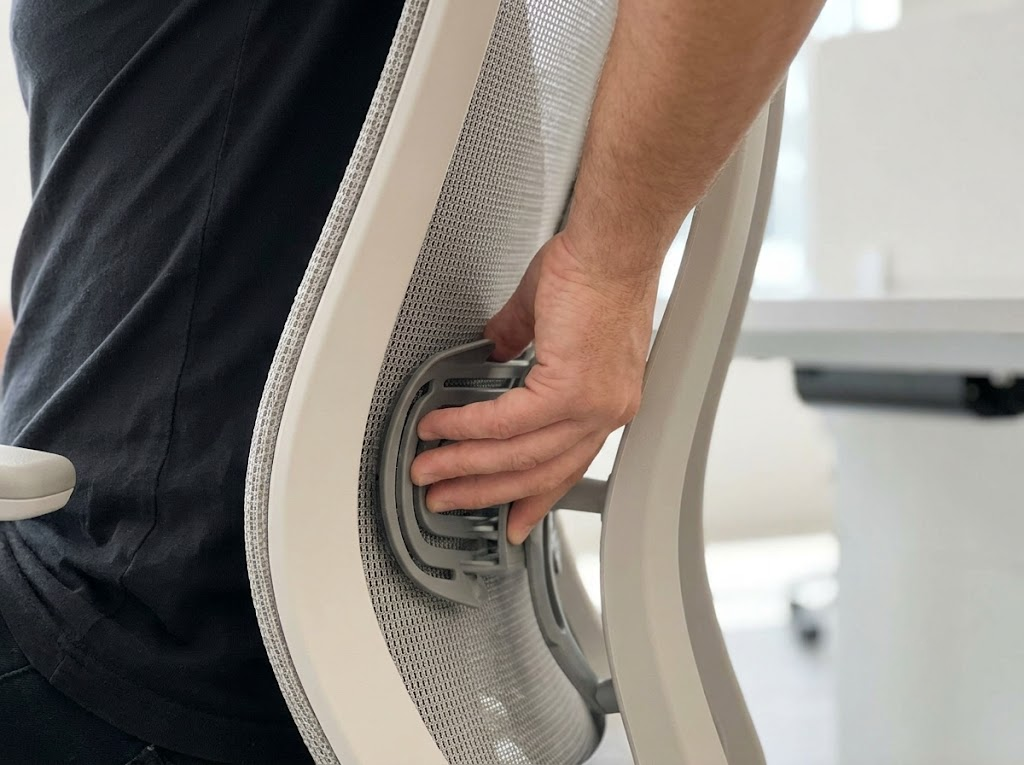 Adjusting lumbar support pad to fit the lower back curve. 